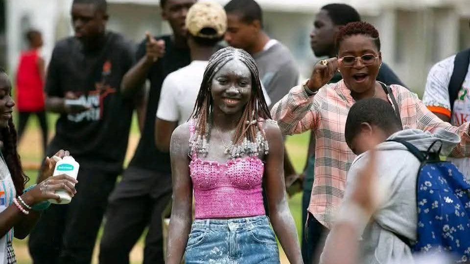 Groupe de jeunes célébrant avec de la farine sur la peau lors d'un événement festif en plein air.