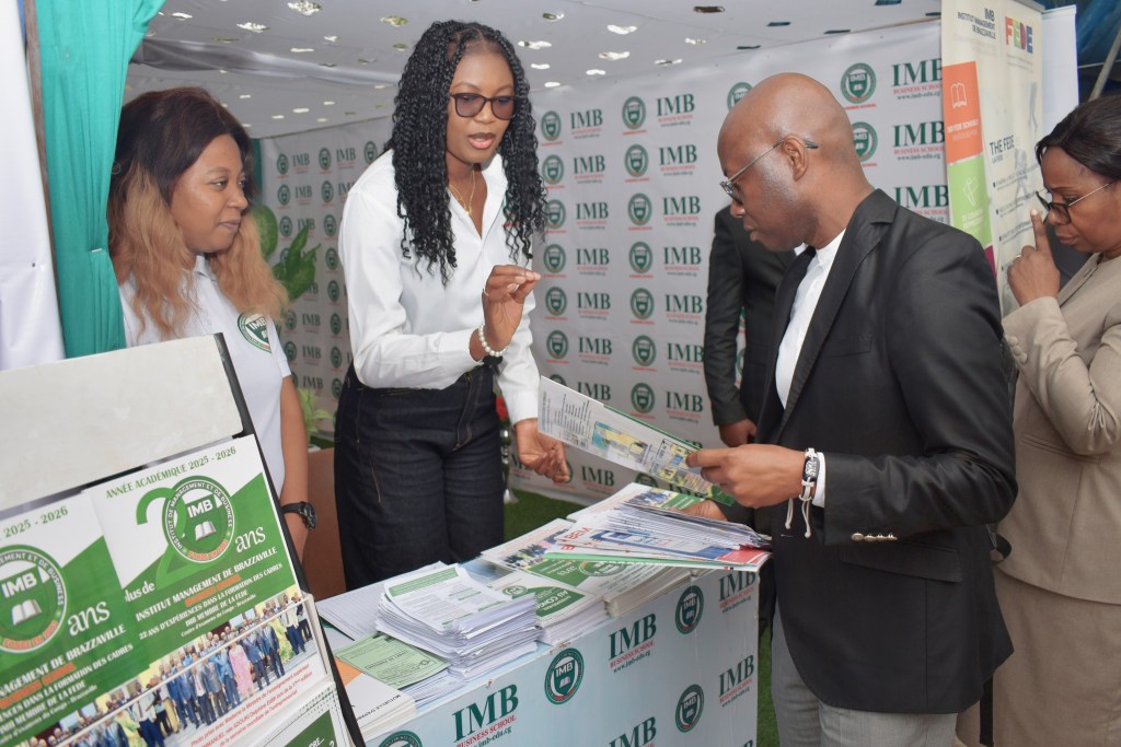Un salon d'orientation avec des participants échangeant des informations au stand d'un institut, mettant en avant des brochures et des inscriptions pour l'année académique.