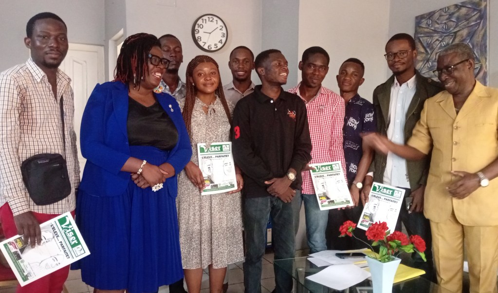 Un groupe de dix enseignants souriants pose ensemble lors d'une formation, chacun tenant des documents dans les mains, dans un cadre professionnel.