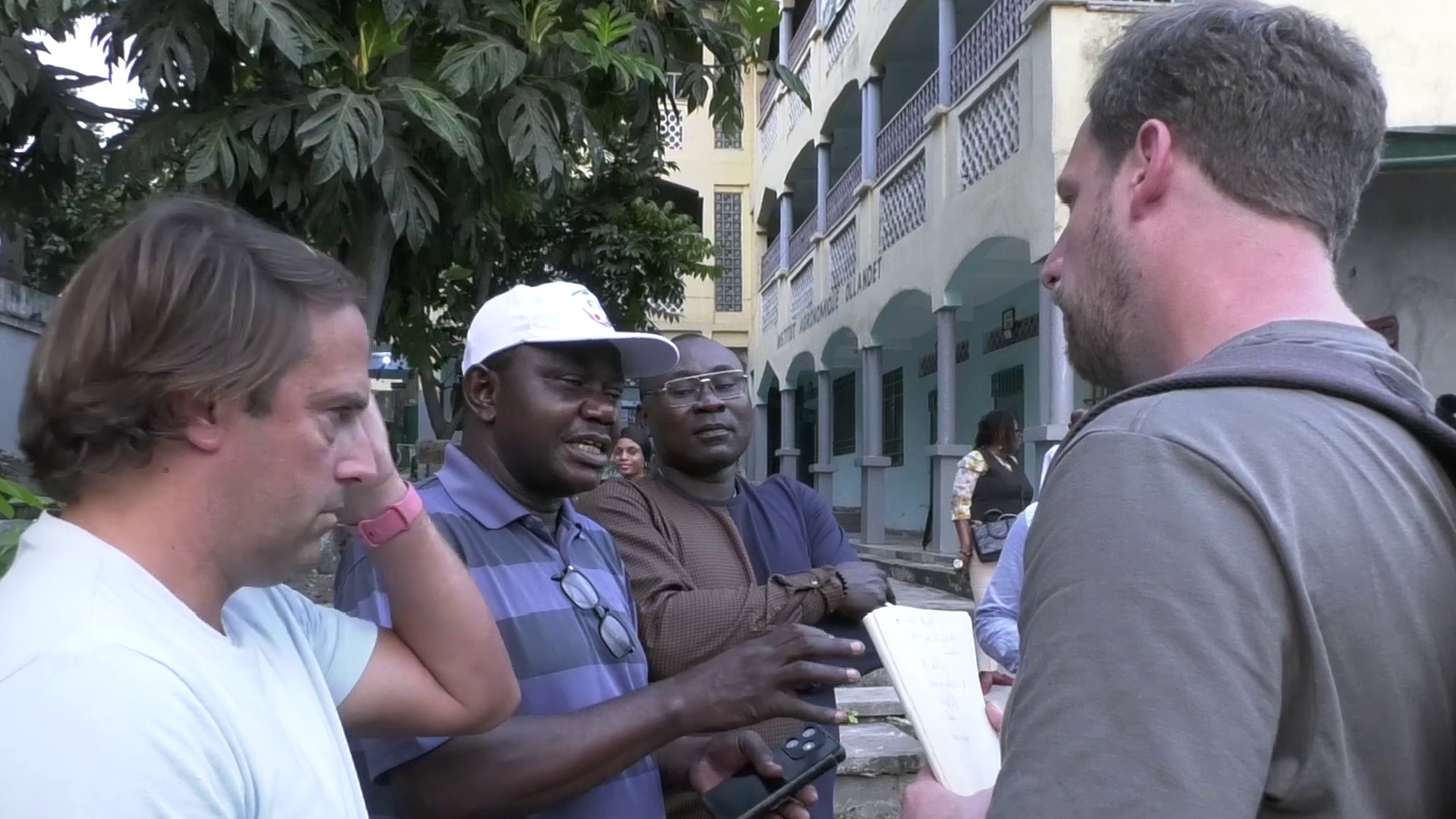 Des membres de la délégation de la Banque mondiale interagissent avec des personnes devant l’Institut Agronomique Ollandet.