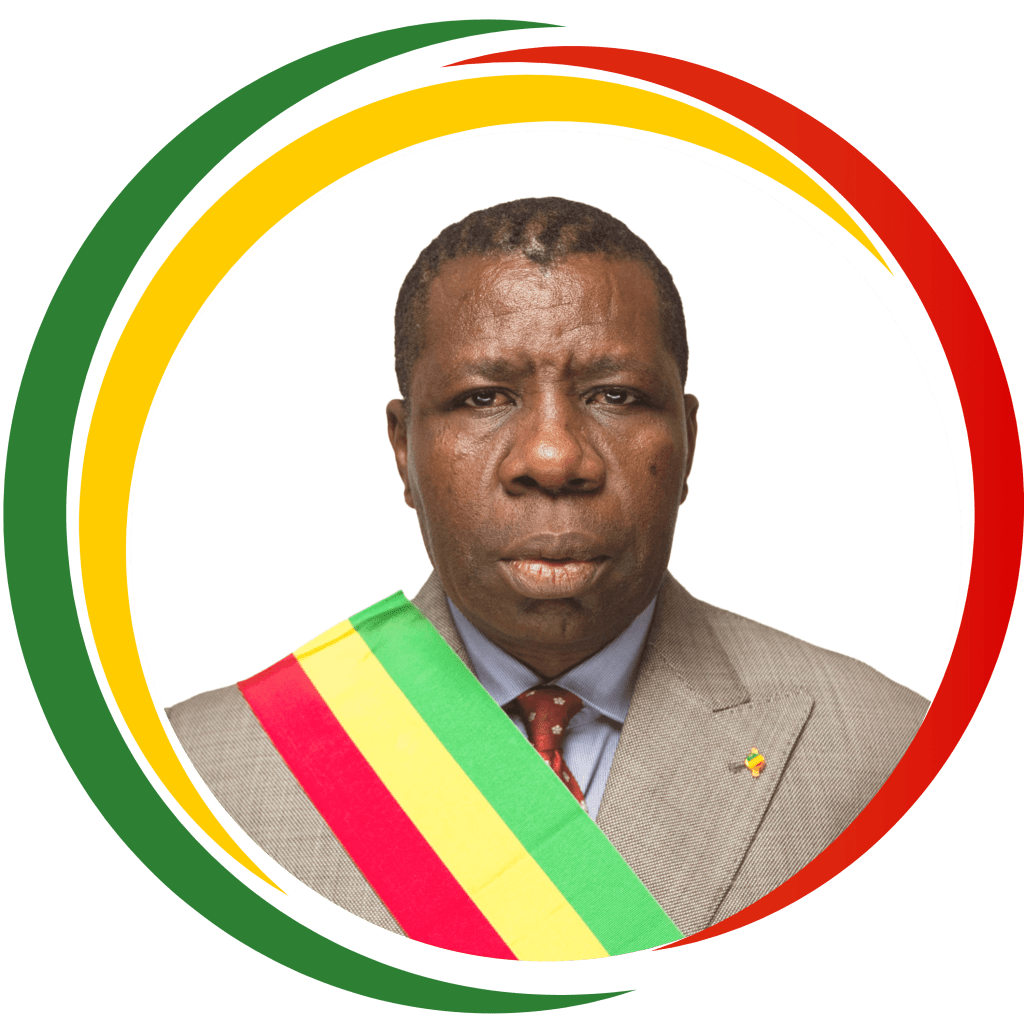 Portrait d'un homme en costume gris portant une écharpe tricolore rouge, jaune et vert, avec un fond graphique circulaire aux couleurs du Congo.