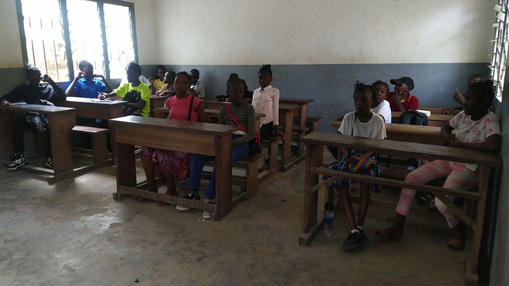 Des élèves assis dans une salle de classe, manifestant de l'intérêt et de l'enthousiasme lors d'un atelier littéraire.